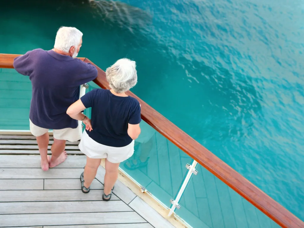 senior couple watching ocean from cruise ships deck