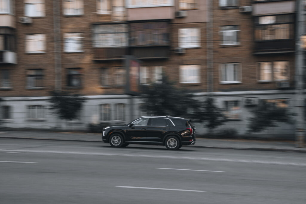 Black Hyundai Palisade car moving on the street.